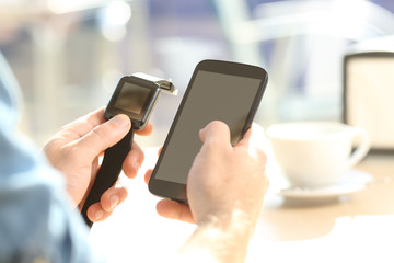 Man hands synchronizing a smartwatch and phone