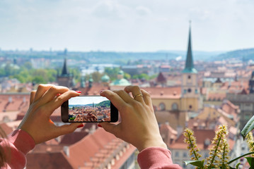 woman taking picture of Old Town in Prague with a smartphone