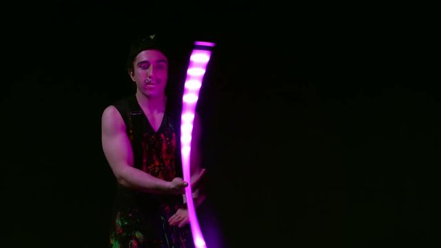 Juggler showing tricks with light balls in the whole dark.