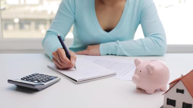 woman counting on calculator and taking notes