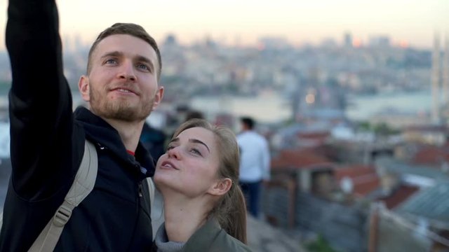 man and woman making selfie on a rooftop slow motion