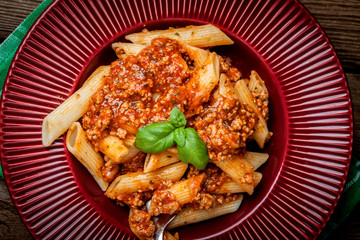 Penne a bolognese on white plate.