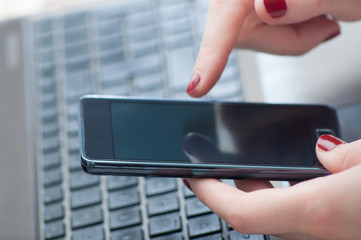 Woman hand typing on mobile phone in office close up