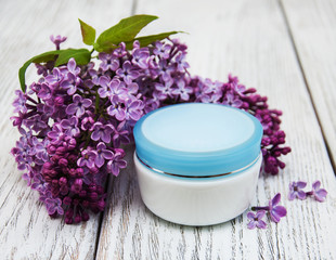 Obraz na płótnie Canvas moisturizing cream and lilac flowers