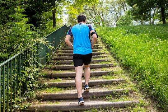 Close Up Of Young Man Running Up The Stairs In A City Park.Runner Man Practice Training On Stairs In A City Park.