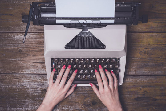 Female hands writing on an old typewriter