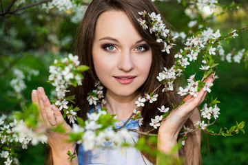 portrait of beautiful woman in blooming cherry garden