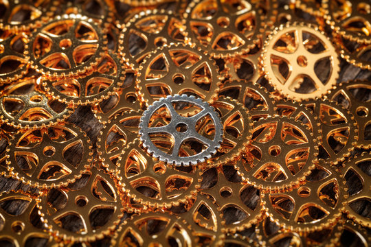 Closeup of bronze cogwheels pile with one silver