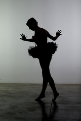 silhouette di ragazza balla in controluce 