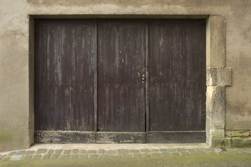 Hintergrund – altes Holztor und Boden aus Pflaster und Asphalt
Background - old wooden door and floor of paving and asphalt
