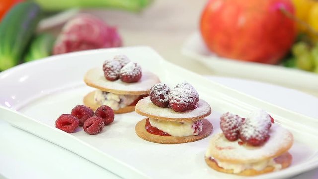 Freshly baked cookies with cream and raspberries