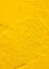 Texture of a rough yellow wall outdoors