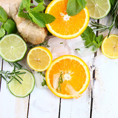 Fototapeta na wymiar Лимон, лайм и апельсин с мятой и розмарином на белом фоне
