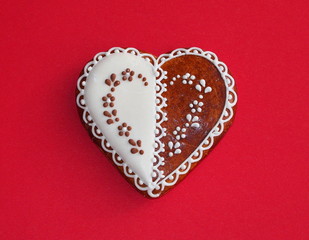 Beautiful gingerbread heart on a a red paper background.