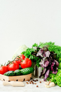 Fototapeta   Fresh juicy ripe summer useful vegetables and greens, red tomatoes , cucumbers , cabbage , lettuce , basil , parsley , dill and salt and spices on a wooden background