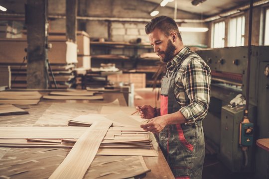 Carpenter doing his job in carpentry workshop.