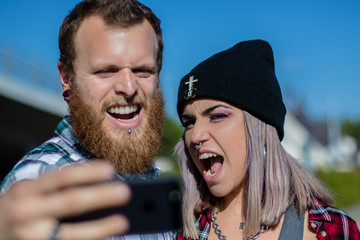 Junges Paar macht Grimassen für Selfies