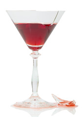 Broken glass with red wine isolated on white.