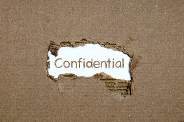 The word Confidential appearing behind torn paper.