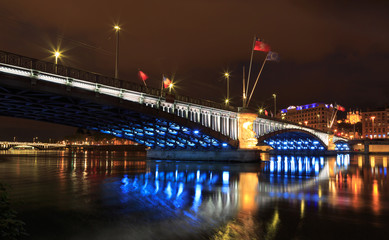 Fototapeta na wymiar Cityscape: illuminated bridge over the Rhone river in Lyon at dusk.