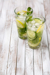 Water with lemon, mint and cucumber on wooden light background. Water Detox.