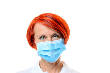 Red headed nurse wearing blue face mask on white