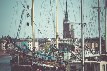 Old city buildings and old boats on water under blue sky in Stoc