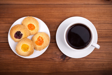 Tasty cookies and coffee on a wooden table.