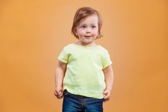 One cute baby girl on orange background