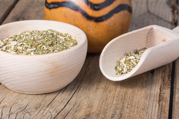 cup of dry yerba mate leaves on wooden table