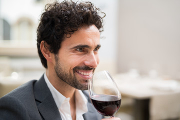 Man enjoying a glass of red wine in a restaurant