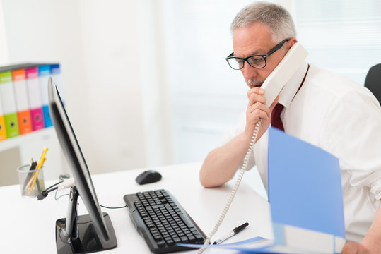 Businessman talking on the phone in his office