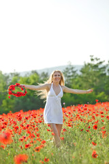 Fototapeta na wymiar Portrait of beautiful woman in a flowers field