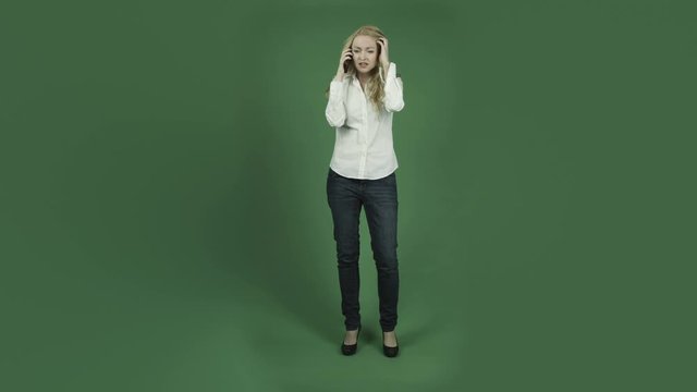 caucasian woman isolated on chroma green screen background sad talking cell phone