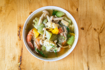 Thai spicy mixed vegetable soup with dried prawn on brown wood table