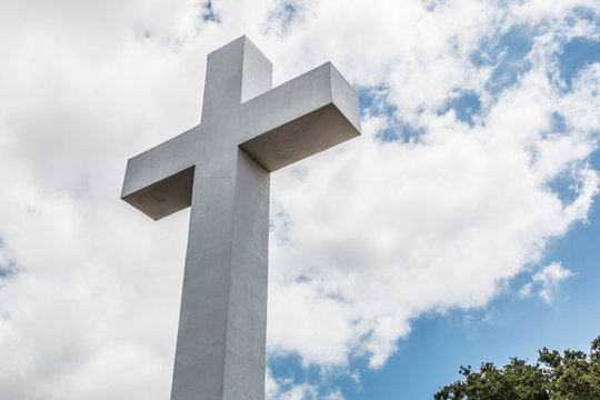 Mt. Helix cross with foliage and a background of a cloudy blue sky in La Mesa, a city in San Diego, California.  