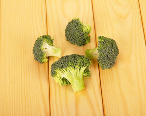 Raw broccoli and ripe on  background of light wood.