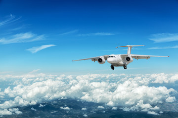 Naklejka na ściany i meble Airplane over the clouds.
