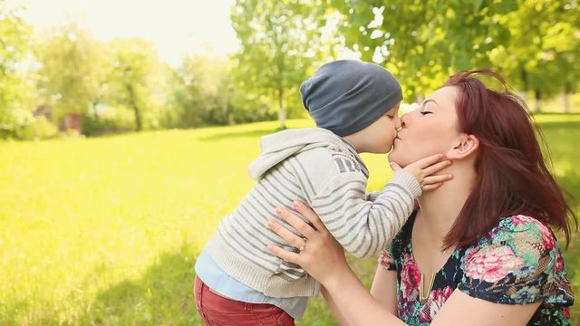 Little son kissing his happy smiling mother