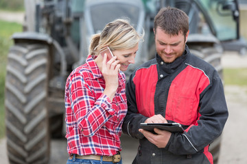 Farmer and technician working together with electronics