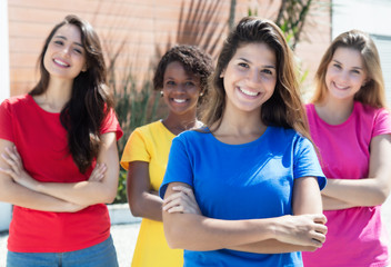 Vier lachende Frauen in bunten Shirts in der Stadt