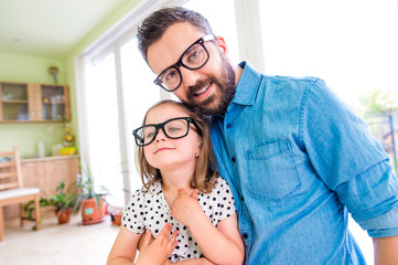 Father with his little daughter in black hipster eyeglasses