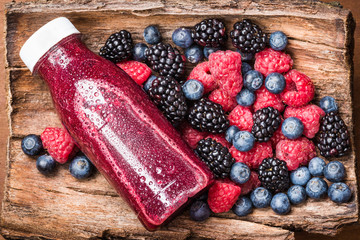 Fresh berry juice or smoothie, top view and fresh various berries, blueberry, raspberry, blackberry.