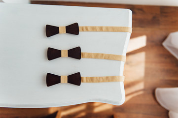 Wooden bow ties on a ivory table