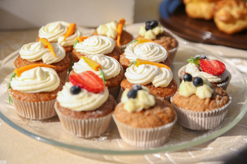 Delicious vanilla cupcake with strawberry frosting and fresh strawberries and blueberries