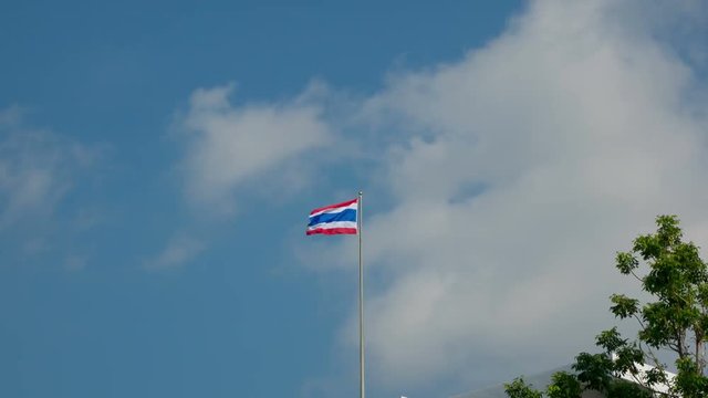 National Thailand Flag On The Cloudy Sky Background. Phuket, Kata Beach. Time Lapse