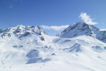 Fototapeta na wymiar Alpine resort of Les Arcs with ski slopes on snowy French Alps mountains