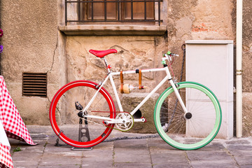 Fototapeta na wymiar A bicycle with the colors of the Italian flag next to a wall in