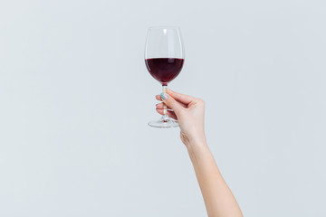 Female hand holding glass with wine