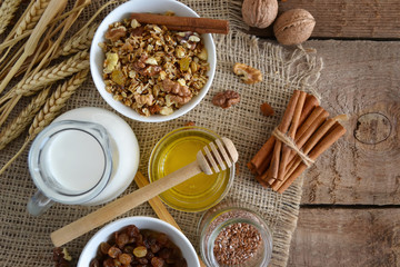 Walnuts, granola, milk and honey on wooden background